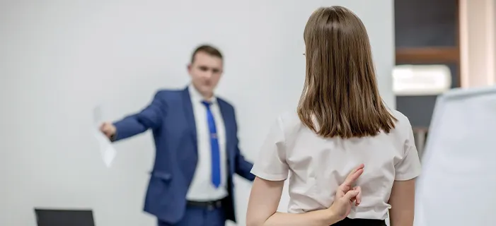 Stressed employee faces hostile boss, implying workplace mobbing and potential sexual harassment.